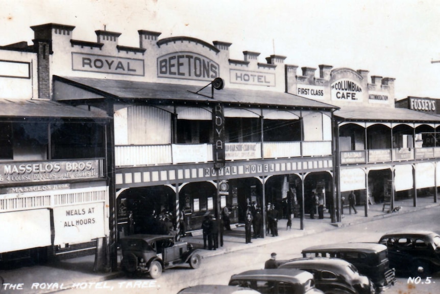 A black and white photo from the 1940s of a country hotel, with vintage cars in the foreground.