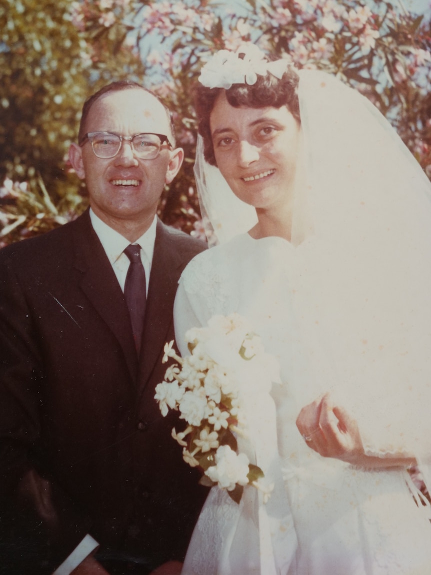 In a historic photo, Stan smiles while standing next to his wife in a wedding dress