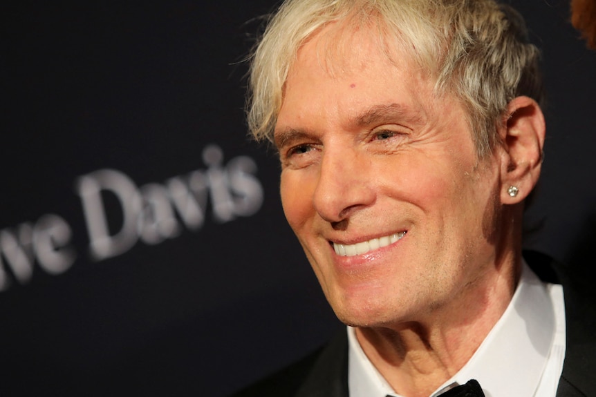 A close up image of Michael Bolton smiling on the red carpet before the Grammys