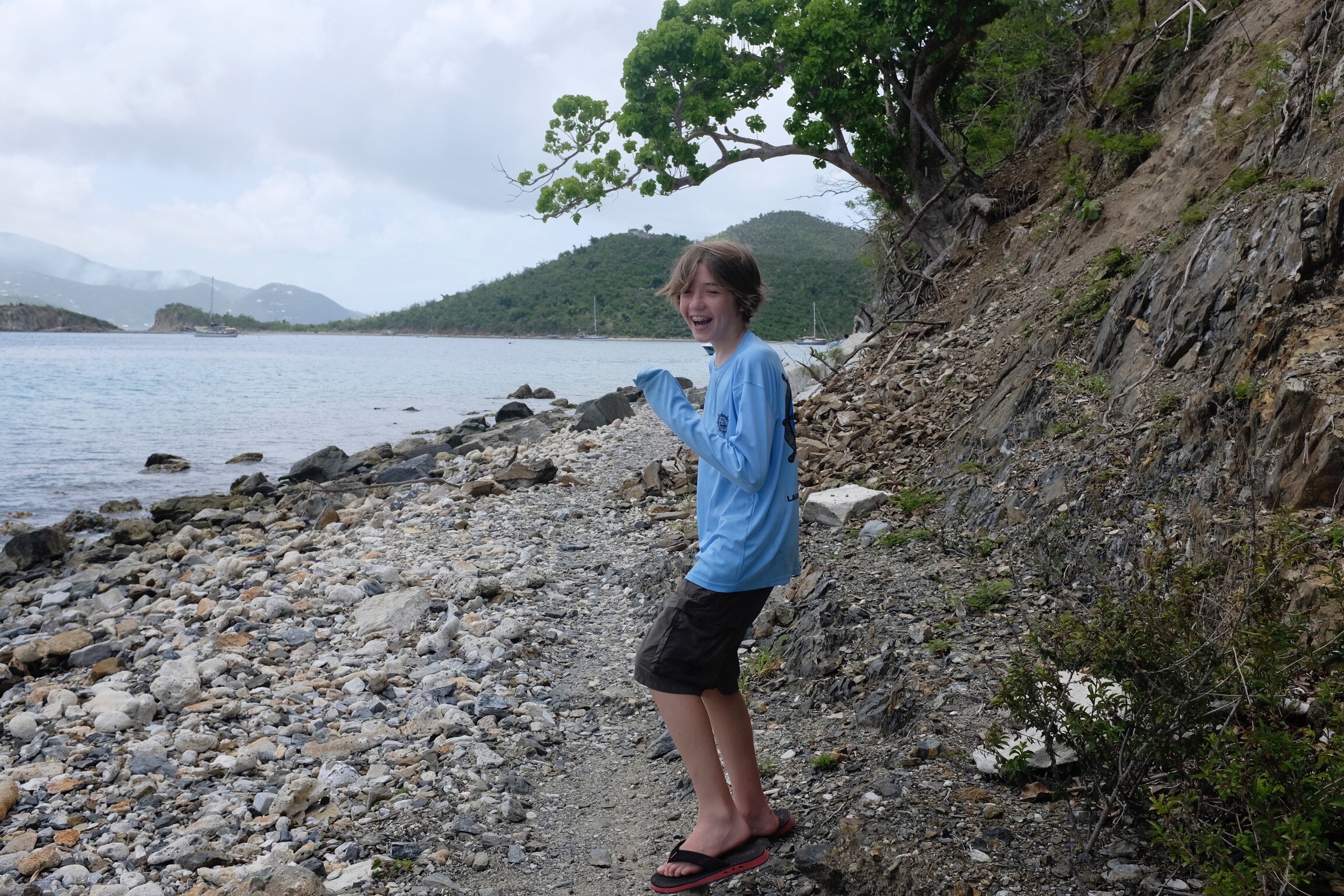 Alexander Neville smiling on a beach.