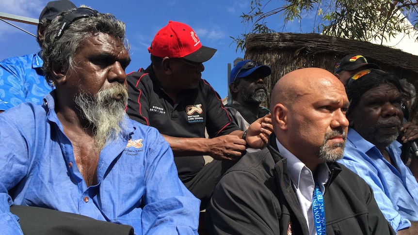 Delegates from the Northern Land Council wear representative merch and sit at the indigenous summit in Uluru