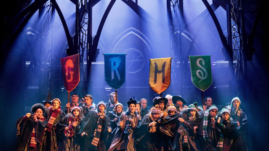 A group of people dressed in wizarding robes on stage