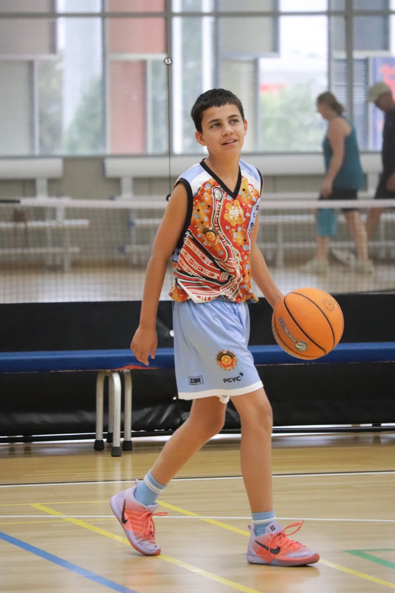 Jurrah Penrith mira a su equipo con una pelota de baloncesto en la mano.
