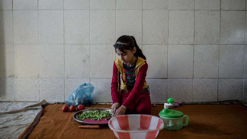 Child prepares food in Iraq house
