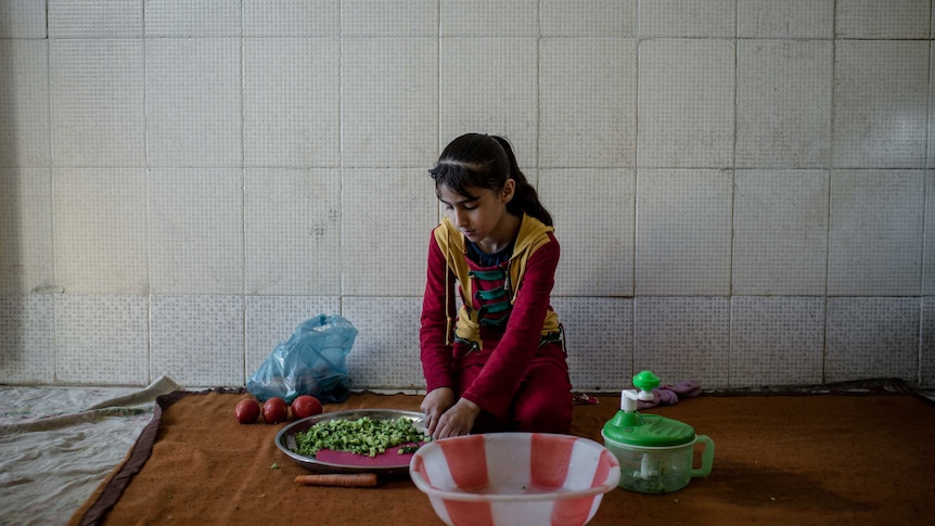 Child prepares food in Iraq house