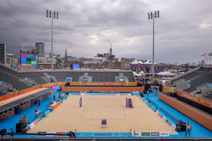 A picture of a beach volleyball court ahead of competition, with grey skies above. 
