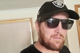 Brett Allford wearing a black hat and black sunglasses