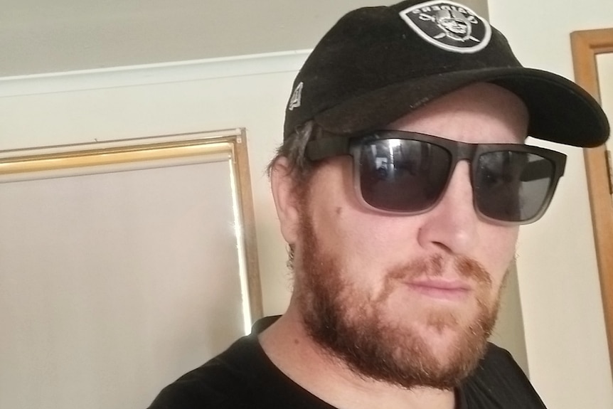 Brett Allford wearing a black hat and black sunglasses