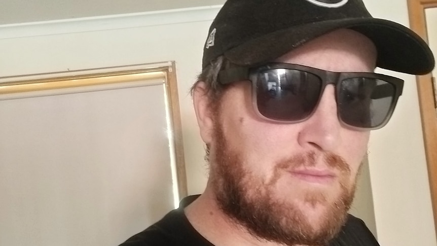 Brett Allford wearing a black hat and black sunglasses