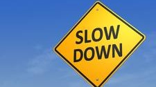 A road sign says slow down.