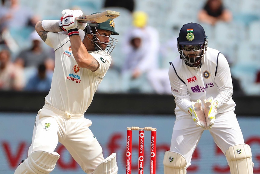Australia batsman Matthew Wade hits a cricket ball away as India wicketkeeper Rishabh Pant watches on at the MCG.