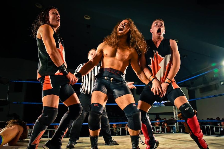 Three wrestlers and a referee in a ring at Melbourne City Wrestling.