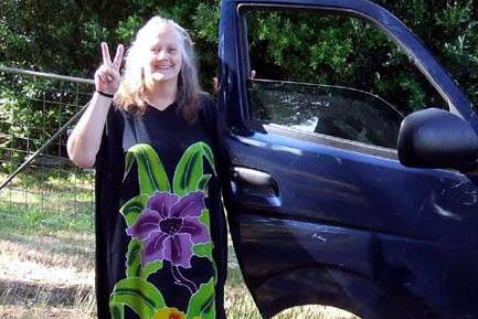 Heather Gladman making peace sign beside car