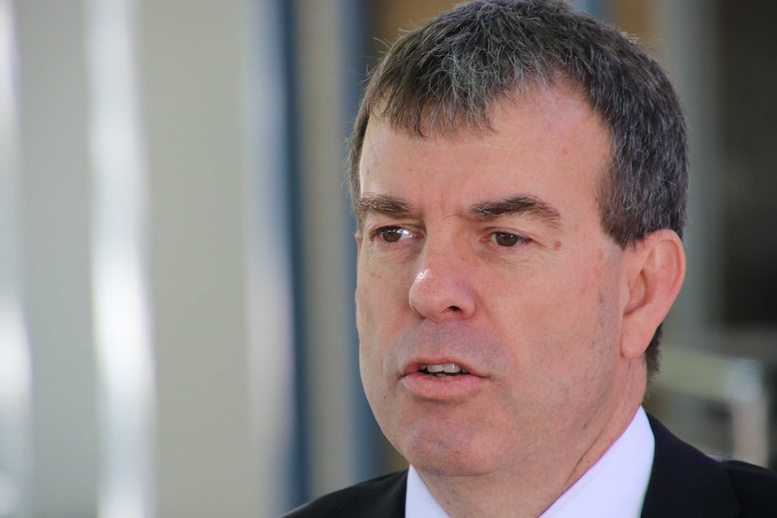 Close-up of middle-aged, brown-haired man in a suit