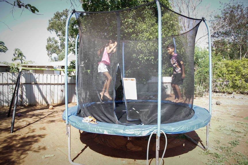 Virginia and Jezurahn Balacky play on the trampoline in their family home in Broome