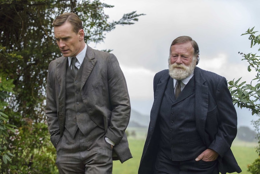 Michael Fassbender and Jack Thompson walk in a rural setting.