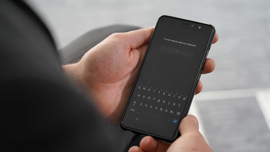 Encrypted mobile phone displaying text that asks for a password.