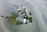 A drone shot of water surrounding a station homestead.