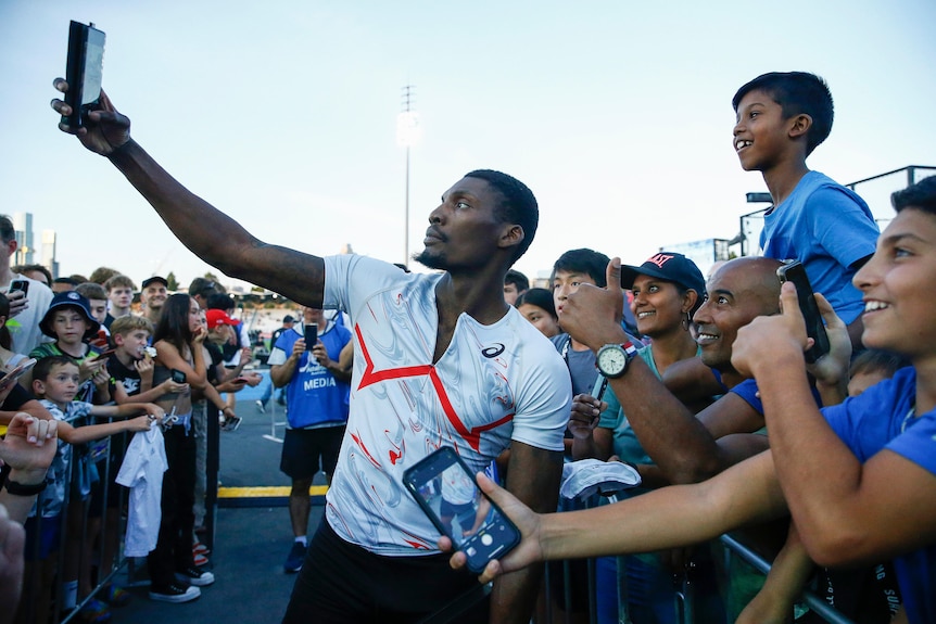 Fred Kerley takes a selfie with spectators at Melbourne's Lakeside Stadium.