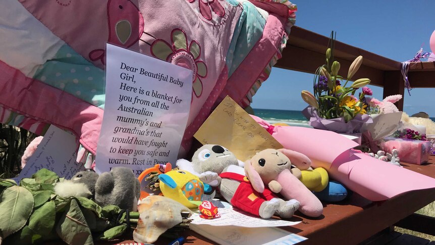 Memorial with blankets, toys and flowers and a letter written to the baby.