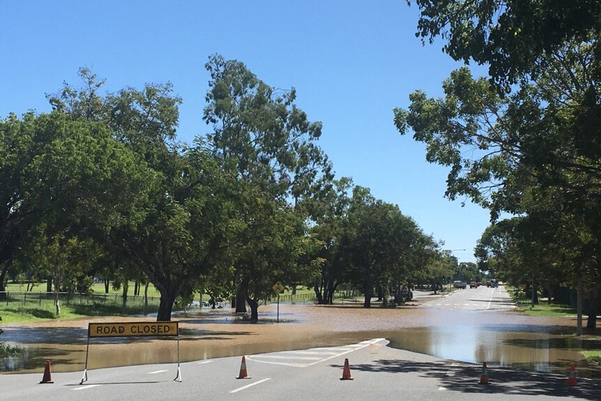 Road closed sign in front of water over a Rockhampton road