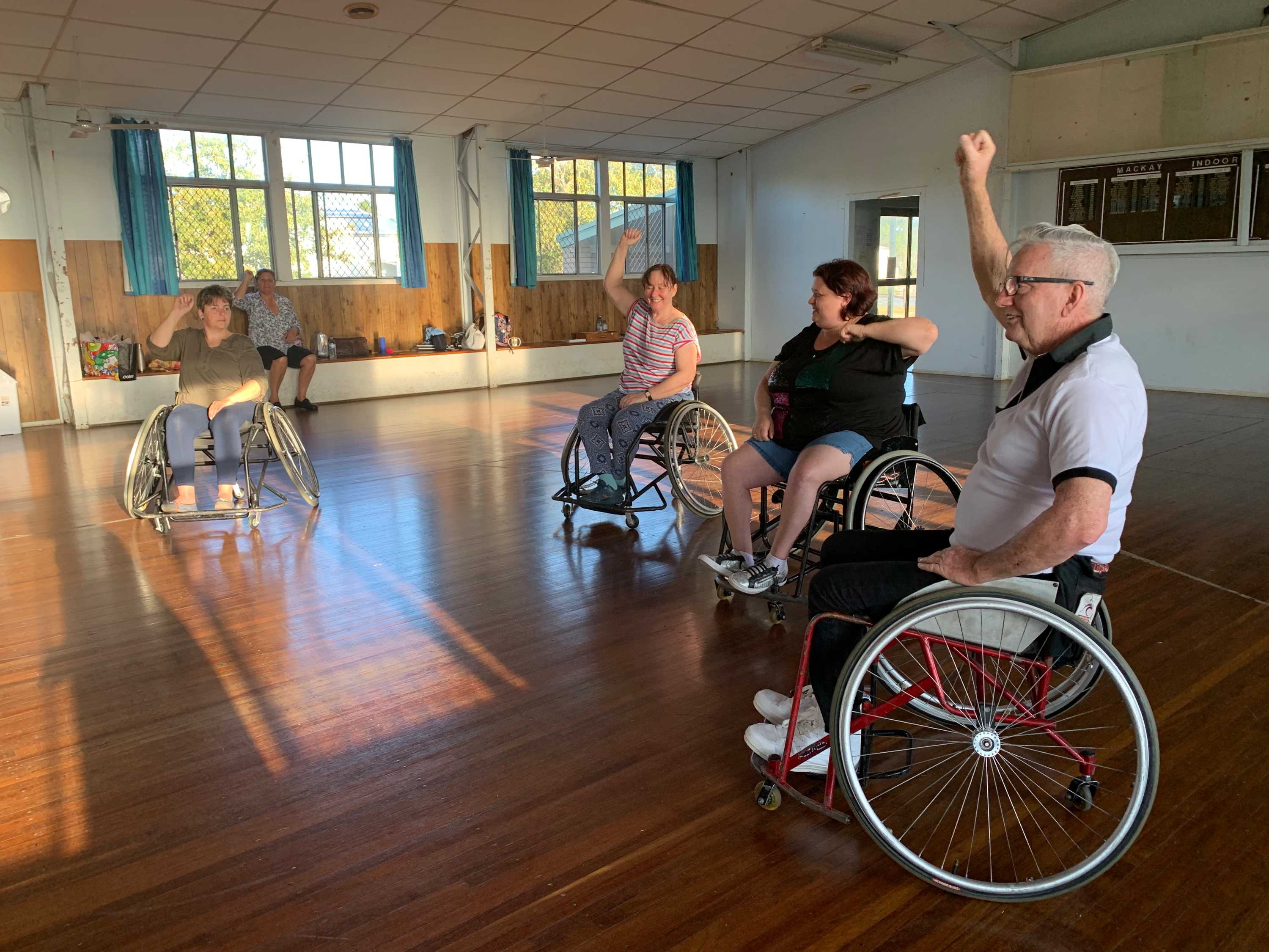 Four people in wheelchairs dancing.