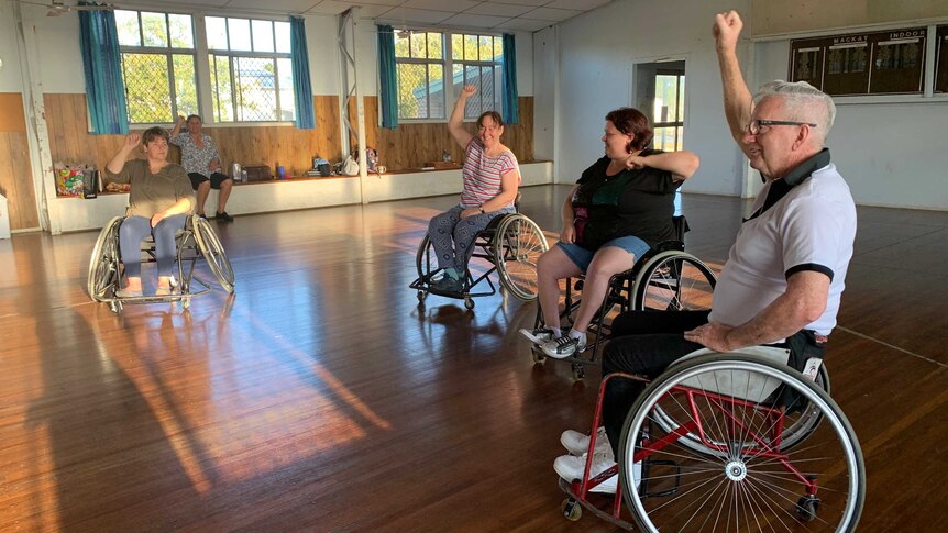 Four people in wheelchairs dancing.