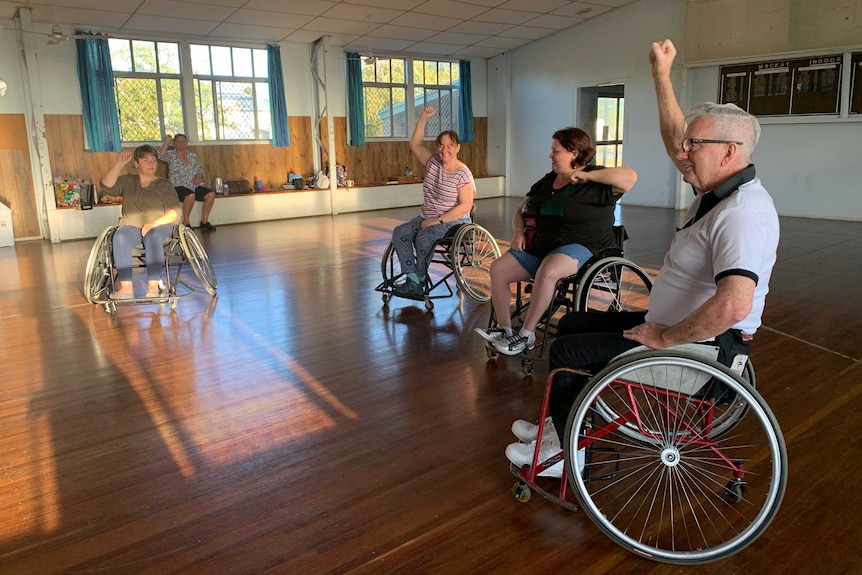 Four people in wheelchairs dancing.