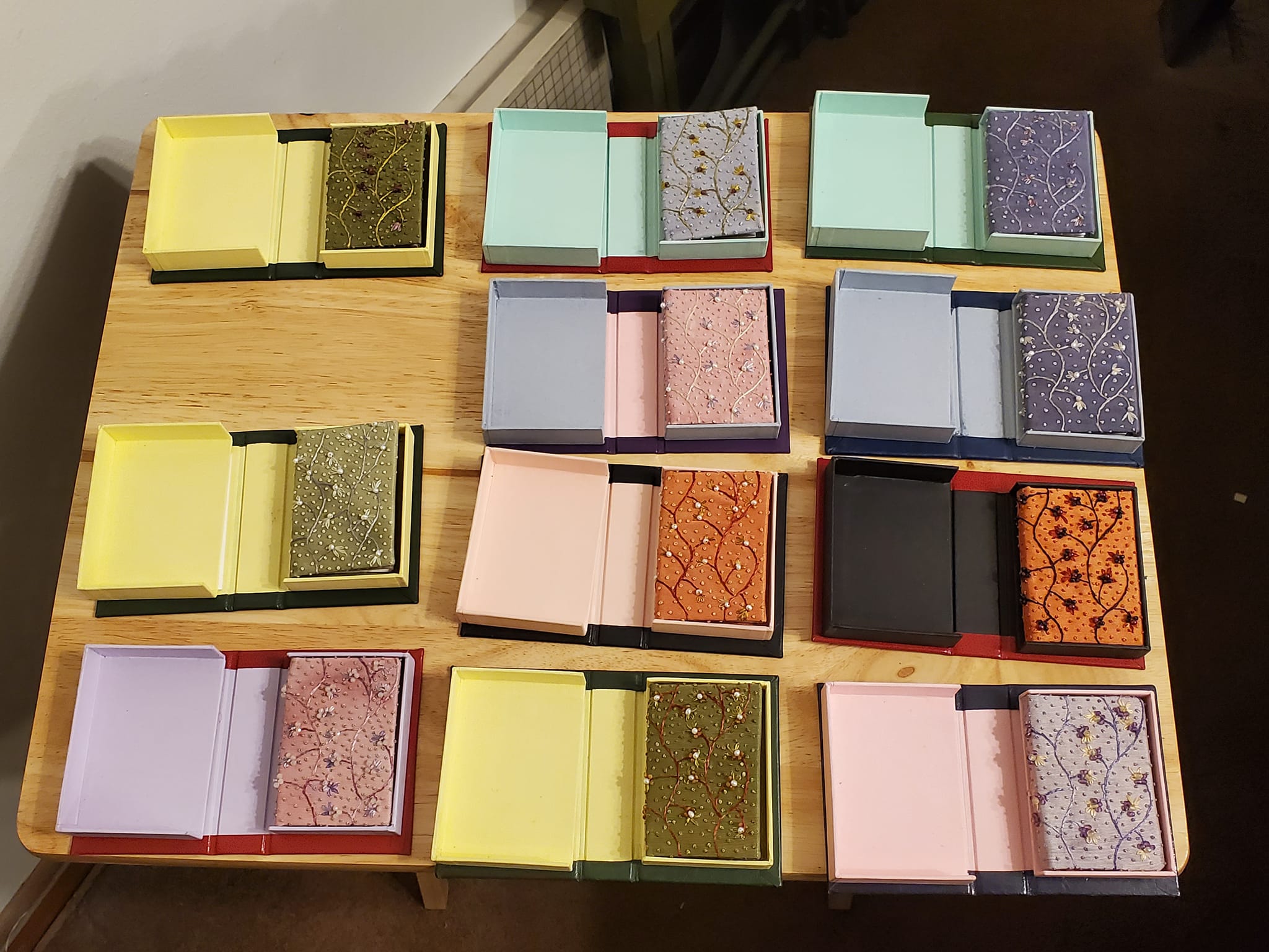 A variety of miniature books presented in their boxes.