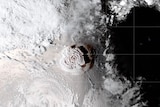 A satellite view of a volcano spewing a plume of ash into the atmosphere