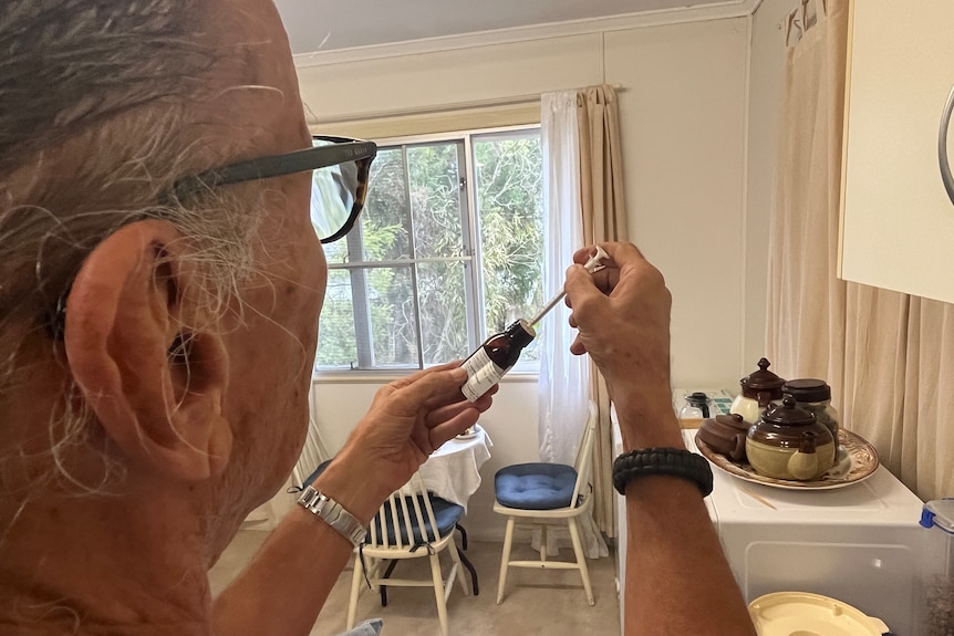 a POV angle of a man dispensing medical cannabis in his kitchen