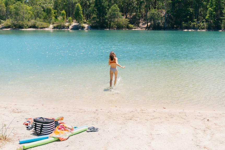 A woman enters the water at Black Diamond Lake in Collie