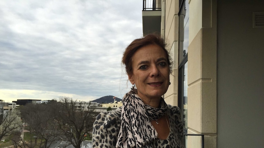 Woman stands on balcony, Canberra