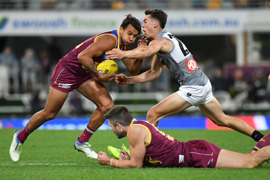 Callum Ah Chee holds onto the ball as he prepares for contact with Connor Rozee