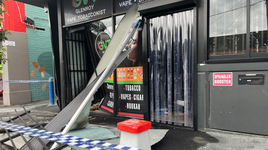 Twisted metal and broken glass lie outside a shop with a sign saying Glenroy Vape Tobacconist.