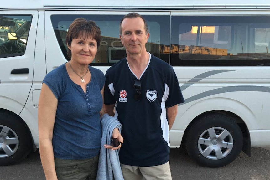 Tourists Caroline and Steve Benstead standing on the main street of Walgett, in front of their van.