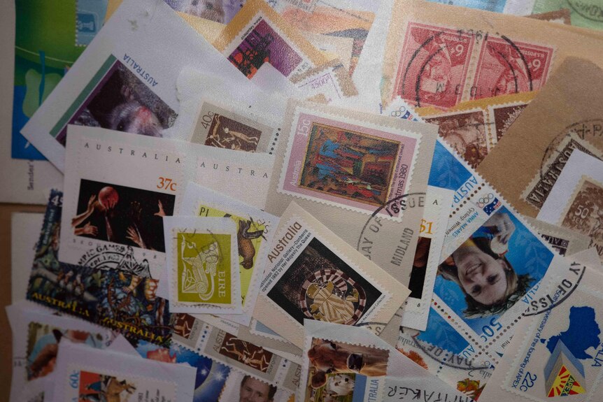 a pile of used postage stamps, all colours and varieties