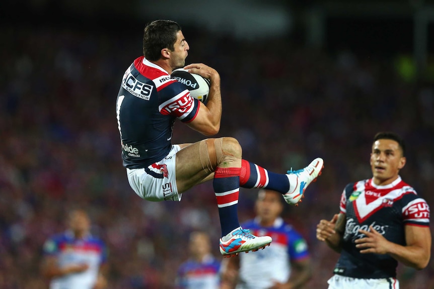 Flying high ... Anthony Minichiello takes a bomb for the Roosters