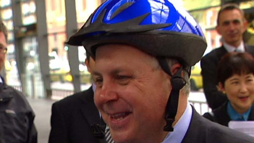 Roads Minister Tim Pallas tries on one of the new disposable helmets.