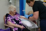 A woman getting her blood taken by a nurse in hospital
