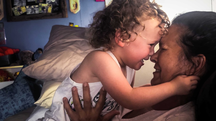 Two-year-old Dolli-Mae laughs in the arms of her grandmother Kay Lutch.