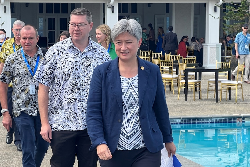 Australian Foreign Minister Penny Wong walks outside by the pool at the Grand Pacific Hotel.
