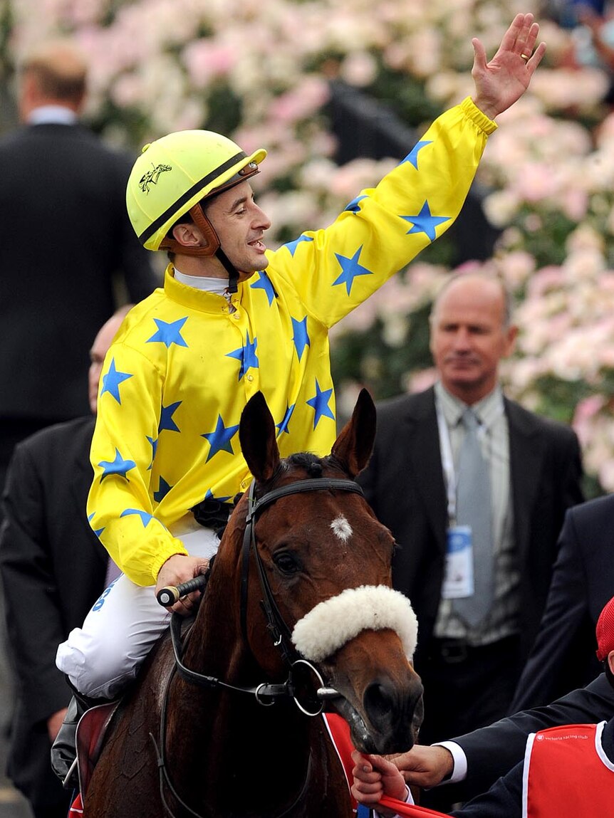 A special day: Christophe Lemaire salutes the crowd after riding Dunaden to glory. (AAP: Joe Castro)