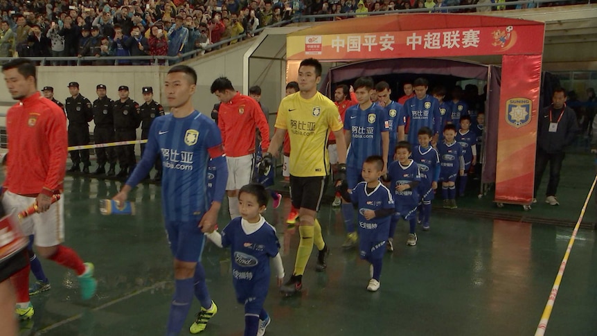 Players for Jiangsu Suning and Guangzhou Evergrande walk out during a Chinese Super League match in Nanjing, China.