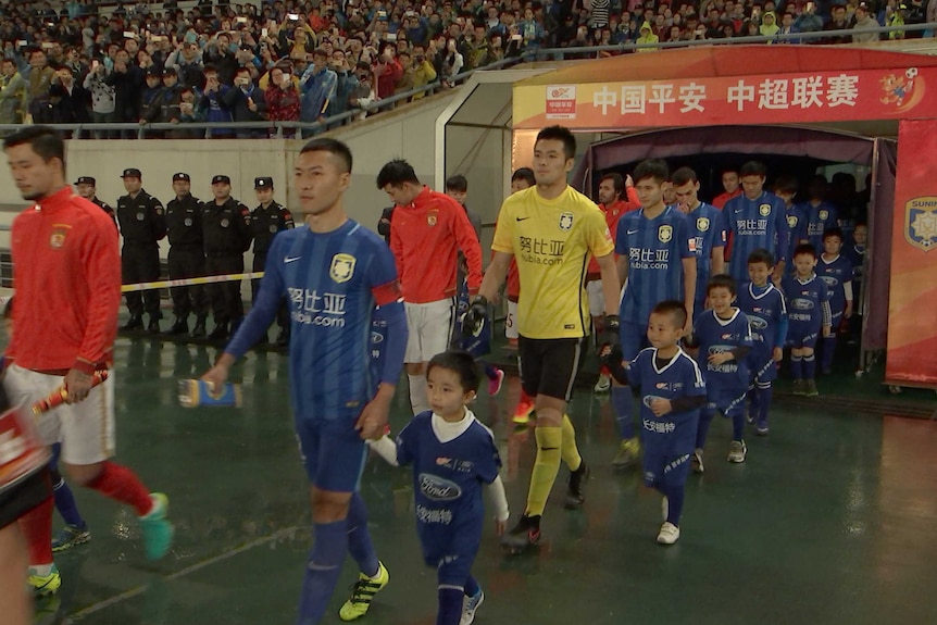 Players for Jiangsu Suning and Guangzhou Evergrande walk out during a Chinese Super League match in Nanjing, China.