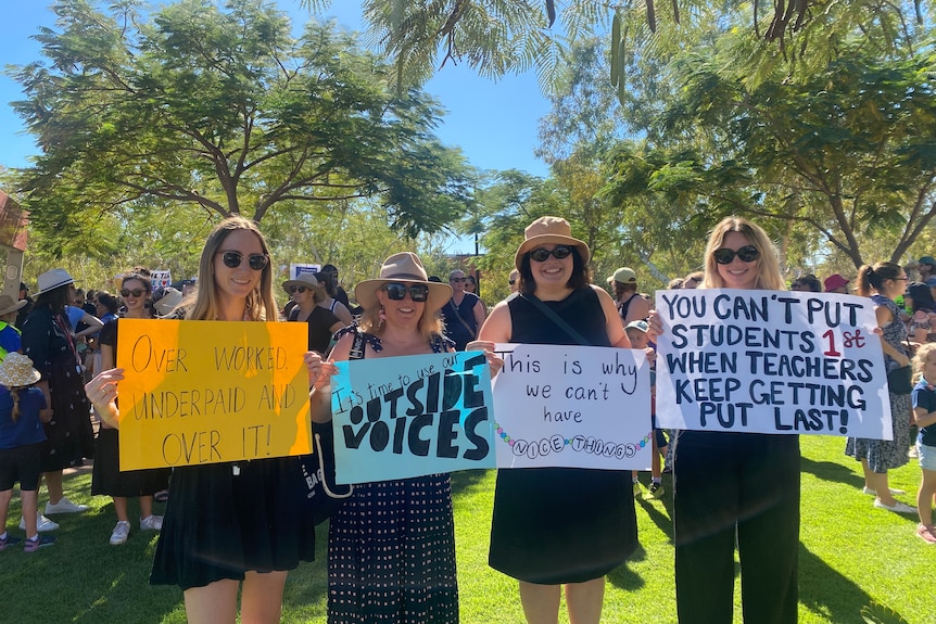 A group of four women holding signs of protest.