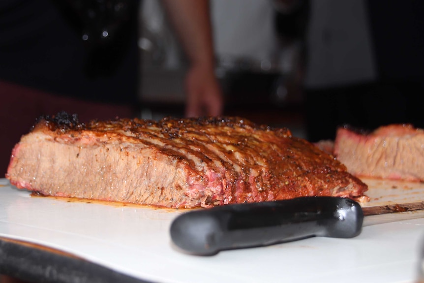 Lump of meat on chopping board, ready to slice