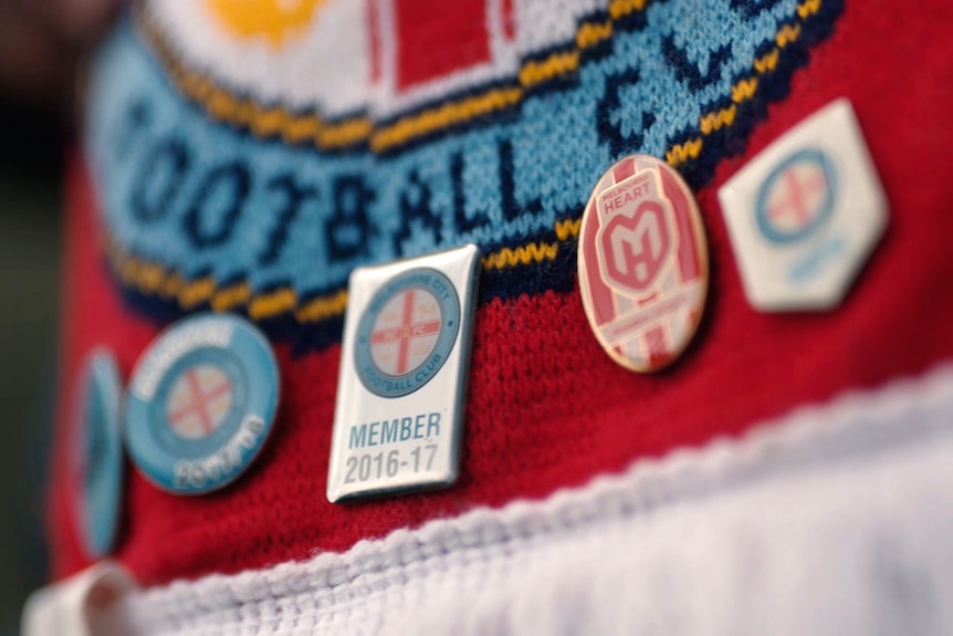 Membership pins for Melbourne City FC are pinned to a Melbourne City scarf.