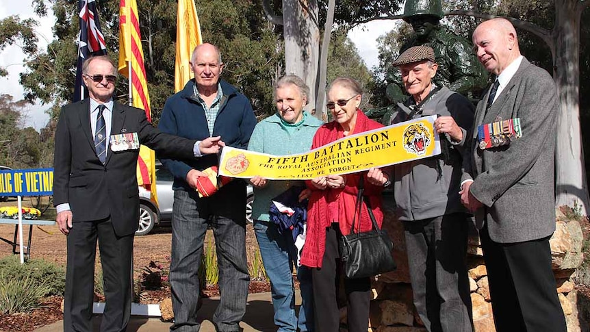 Family group holding a yellow banner