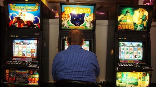A punter playing the poker machines in a Sydney club, May 3, 2004.